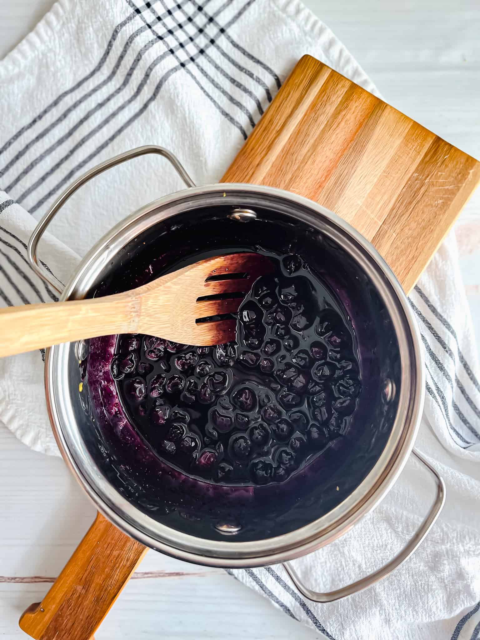 Blueberry lemon compote simmering in a medium sized steel pot. 