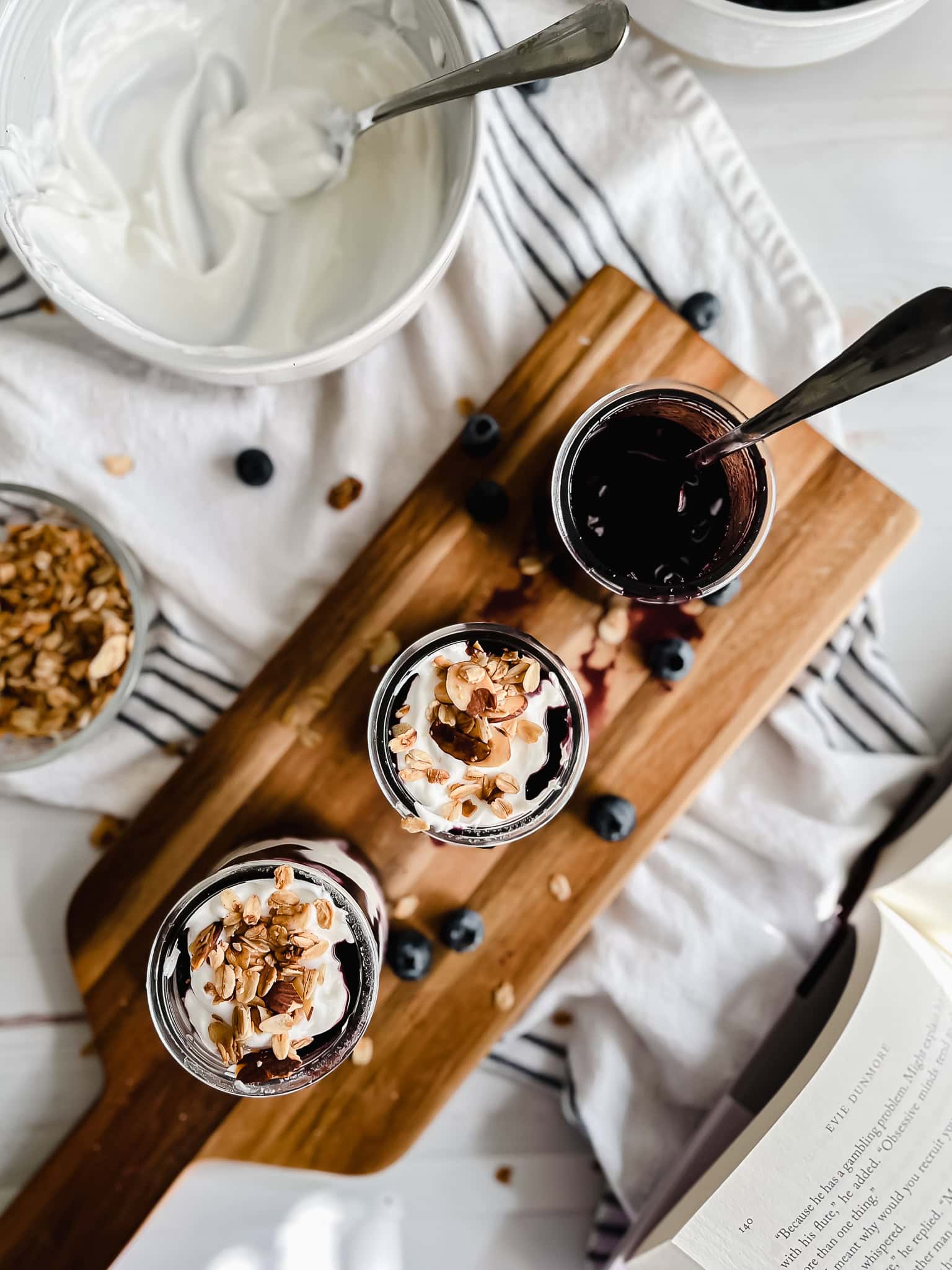 Assembling two blueberry parfaits. 