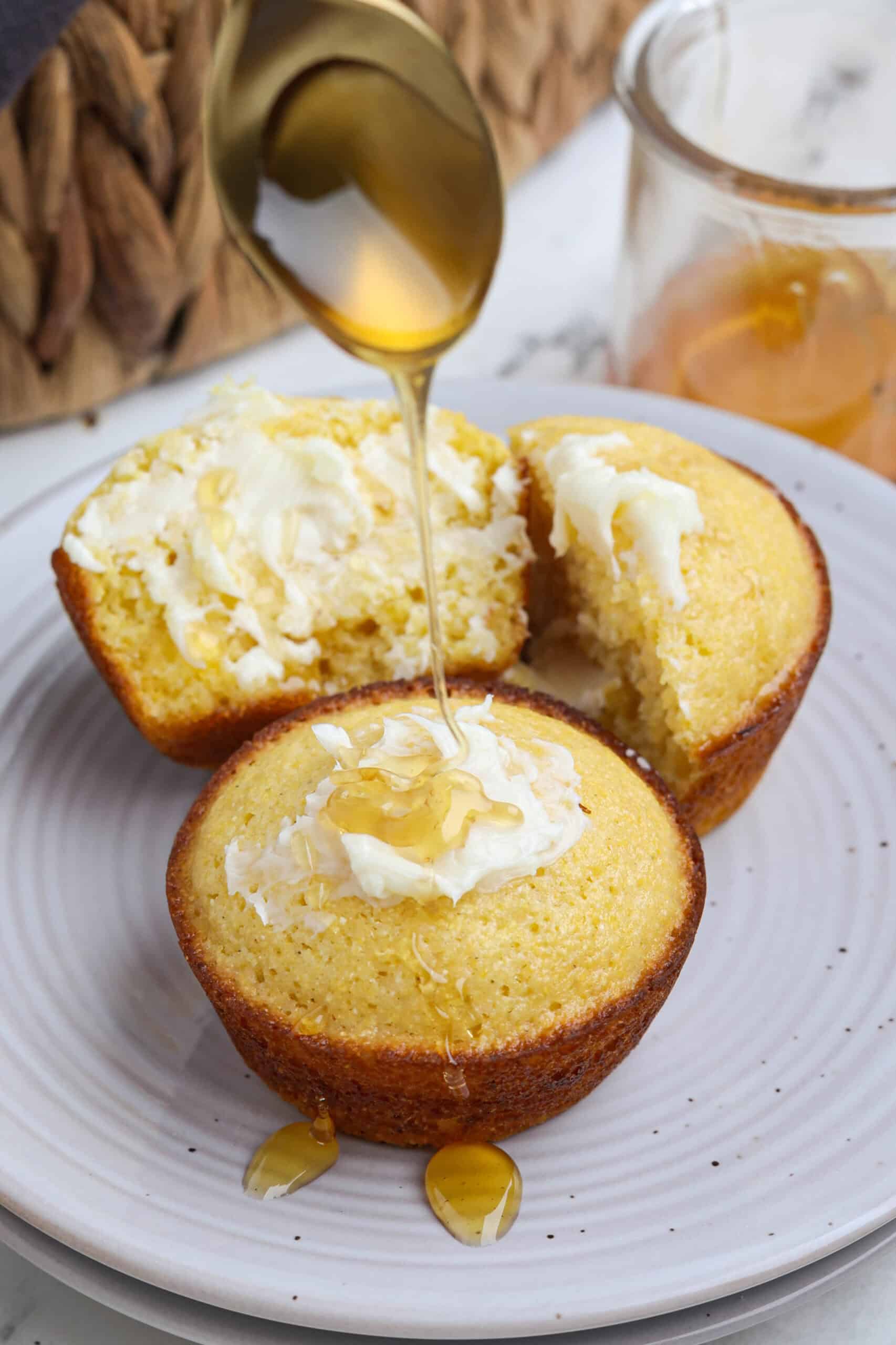 Honey cornbread muffins with butter and honey on top.