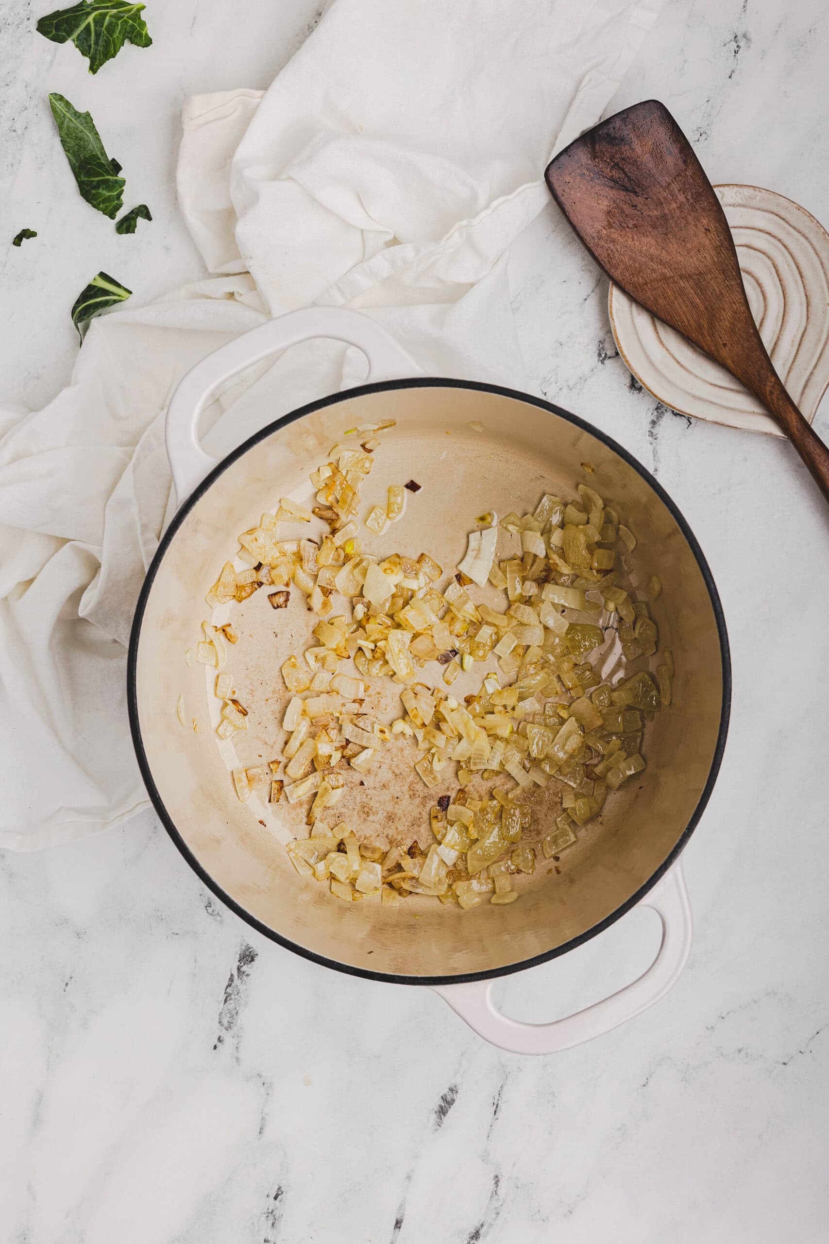 Onions sautéing in a Dutch oven as the base for collard greens.