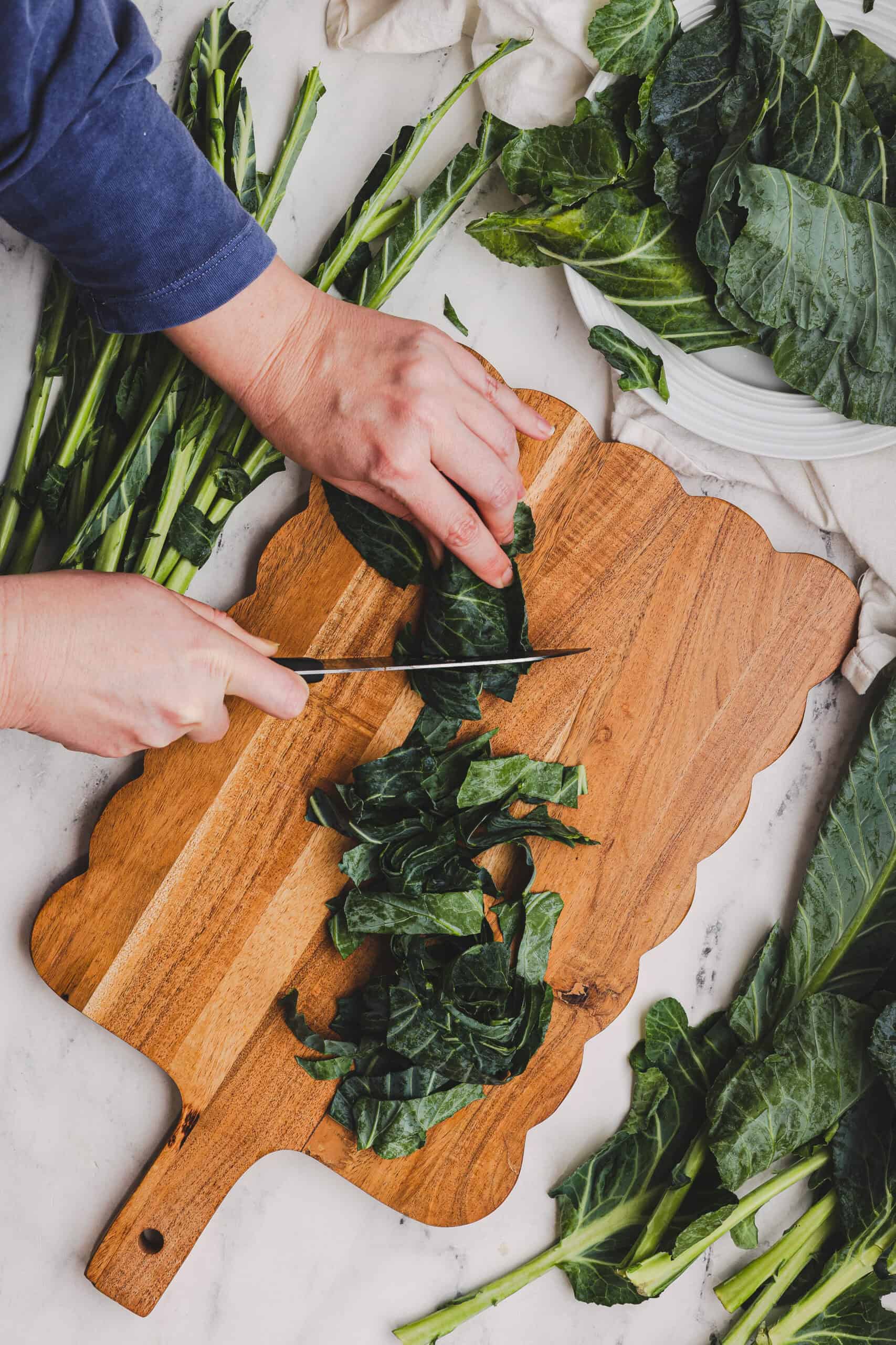 Slicing collard green leaves into strips for cooking.